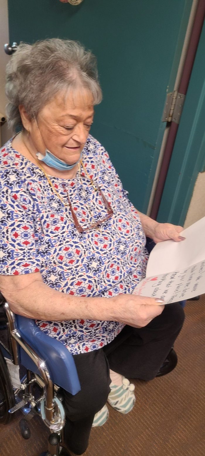 A JGS Lifecare resident reading her letter of love from the community