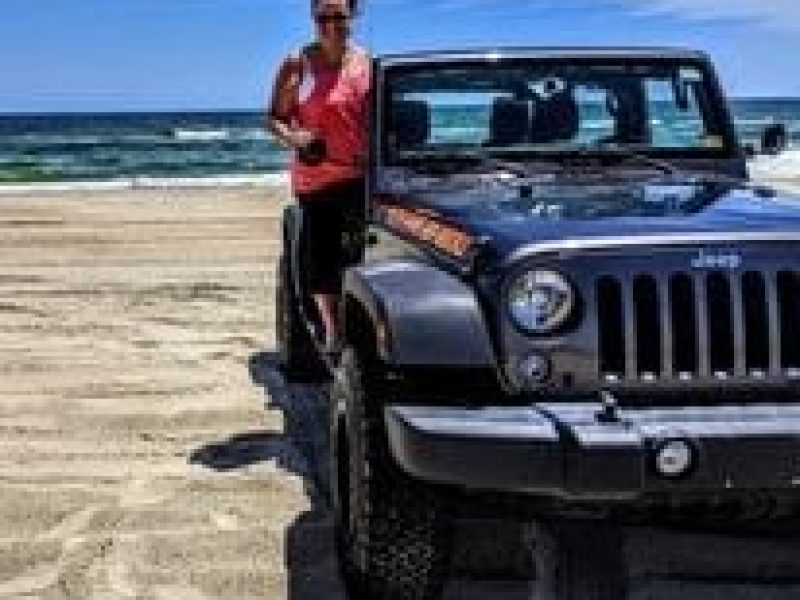Mary-Anne posing with a Jeep