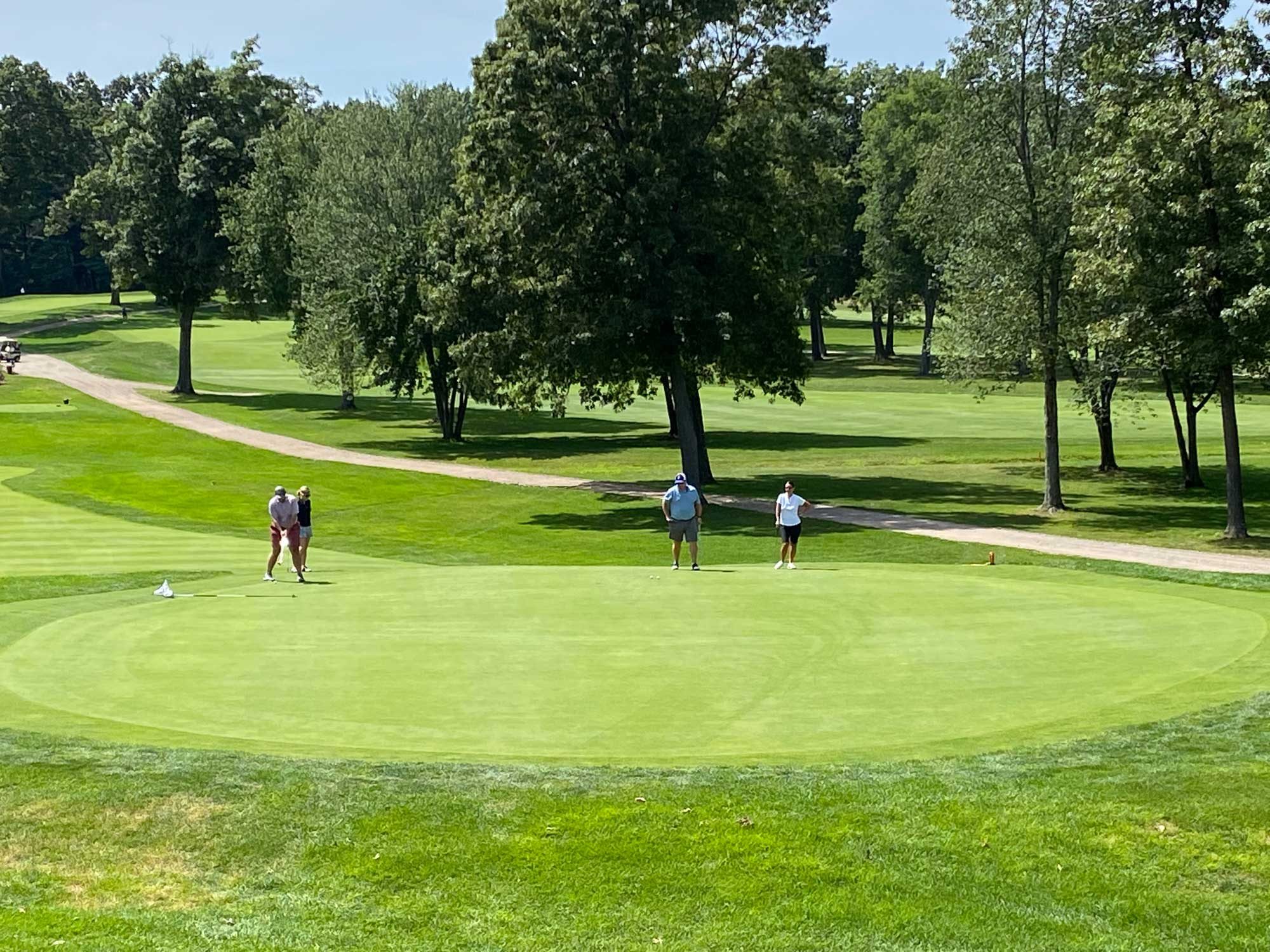 Golfers on the green, putting, at the Frankel Kinsler Tournament