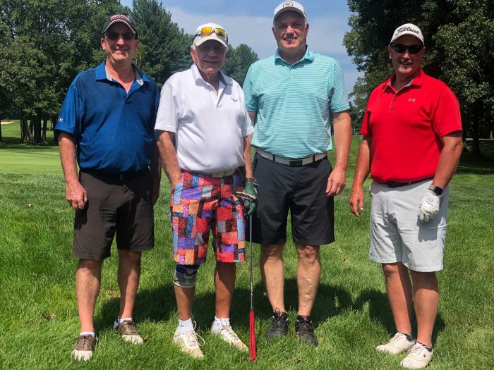 A golf team of four men at the Frankel Kinsler Golf Tournament