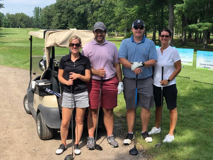Megin, Adam and two others golfing at the Frankel Kinsler Tournament