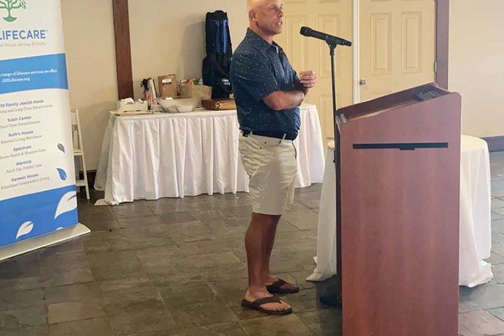 A speaker speaking at the Frankel Kinsler Golf Tournament