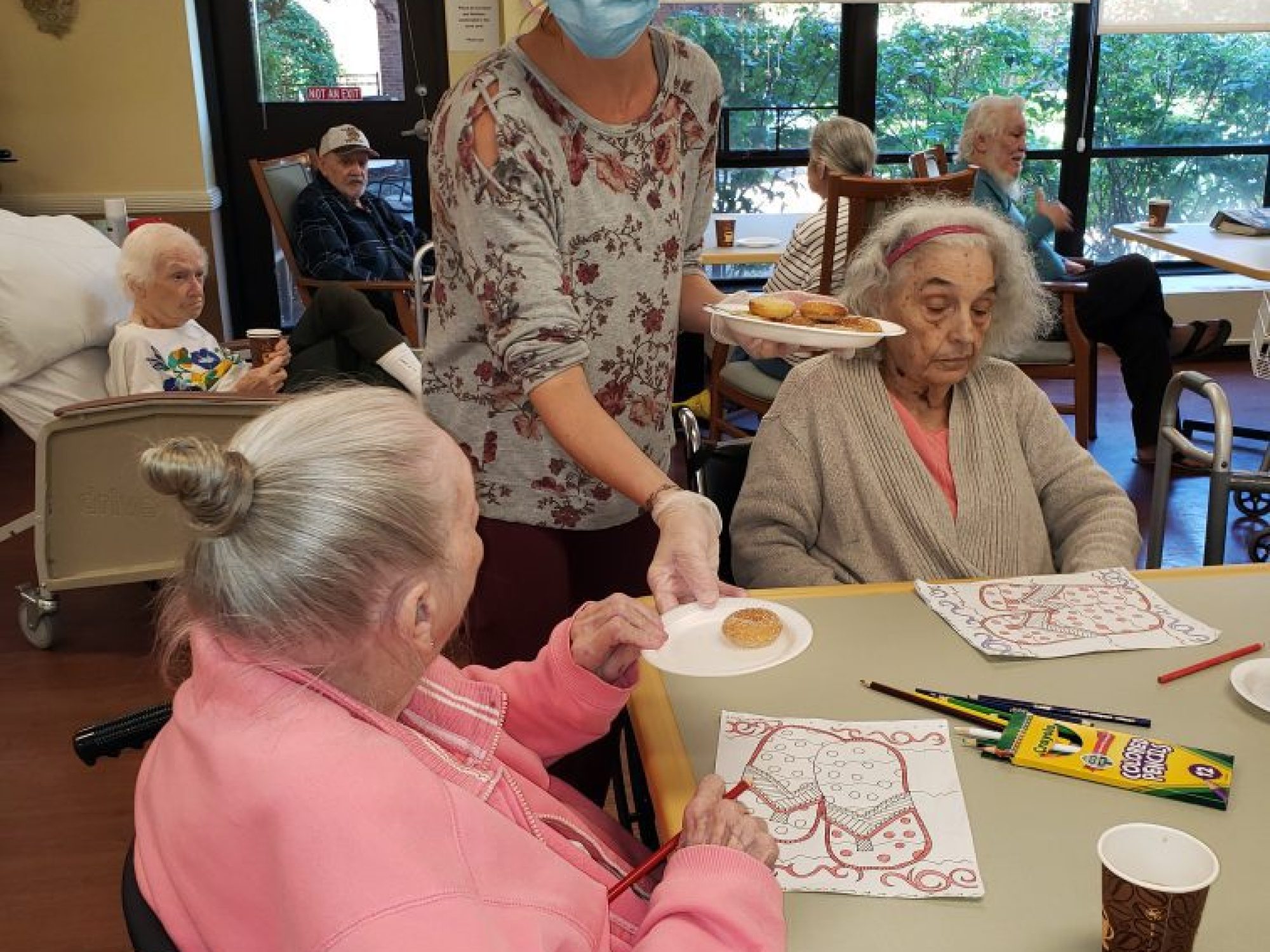 Holly, a staff member at JNH, hands out homemade donuts to residents.
