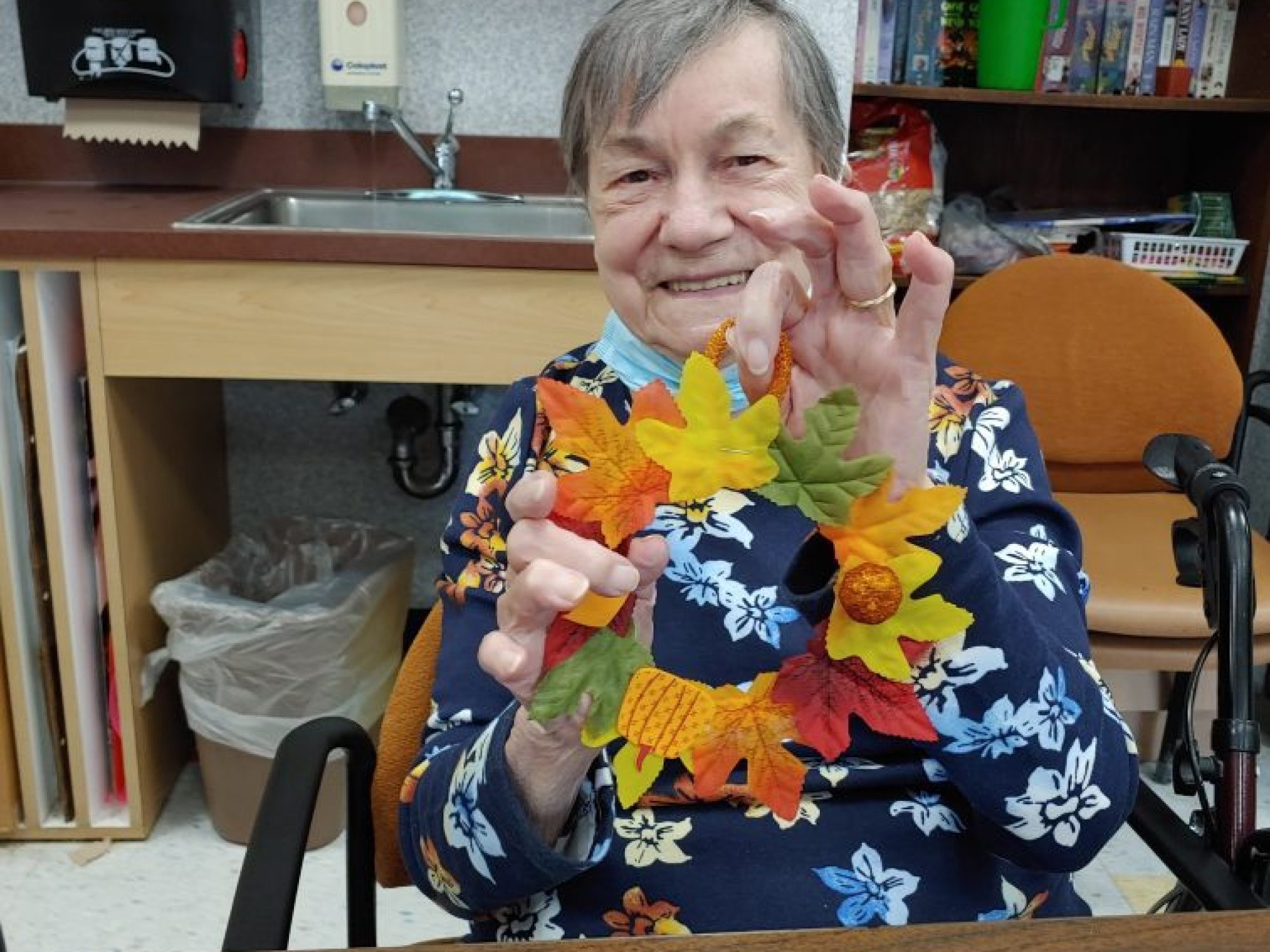 A resident with her fall leaf craft