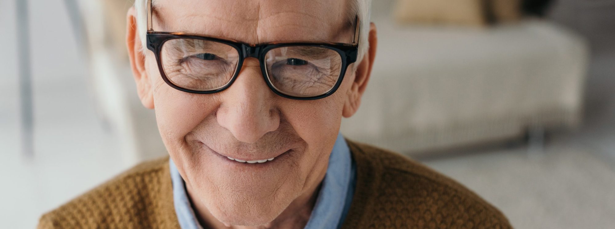 A close up portrait of an older man wearing glasses.