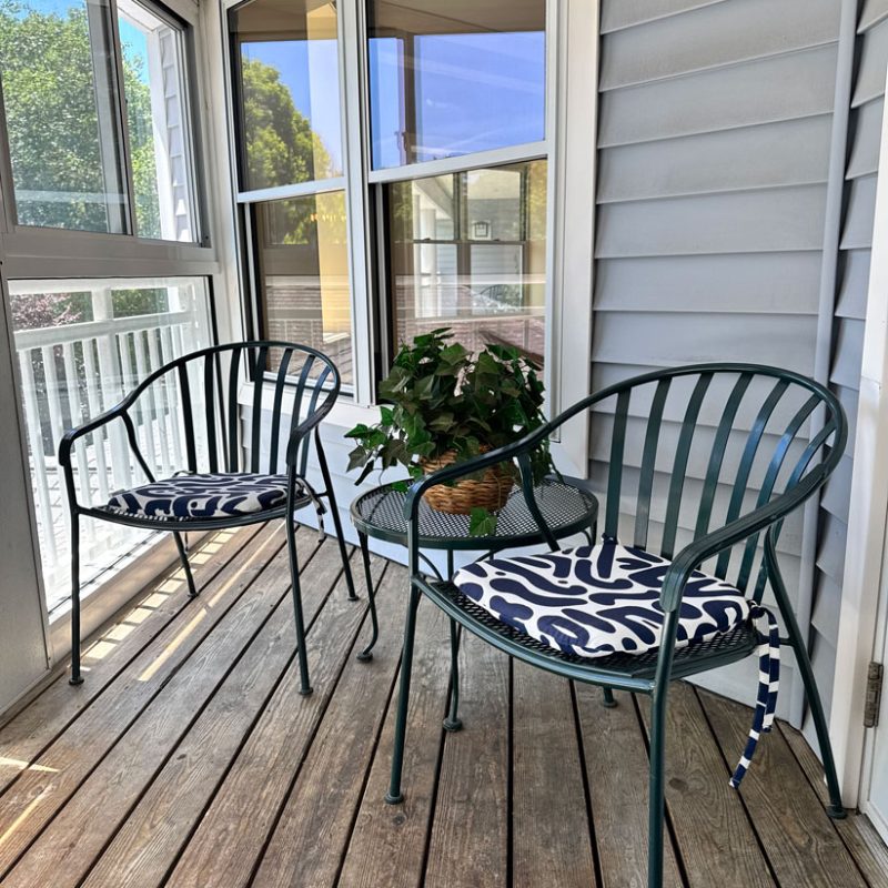 Two chairs on a screened in porch.